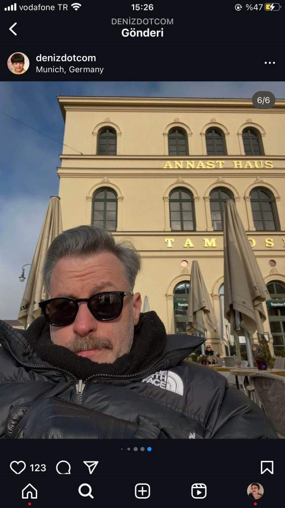 Selfie of Deniz Kosan in front of a historic building in Munich wearing sunglasses